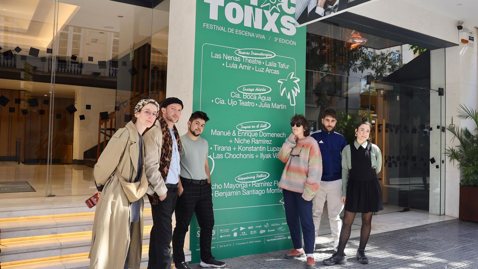 Algunos de los participantes y la organizadora posan con el cartel promocional de la tercera edición.