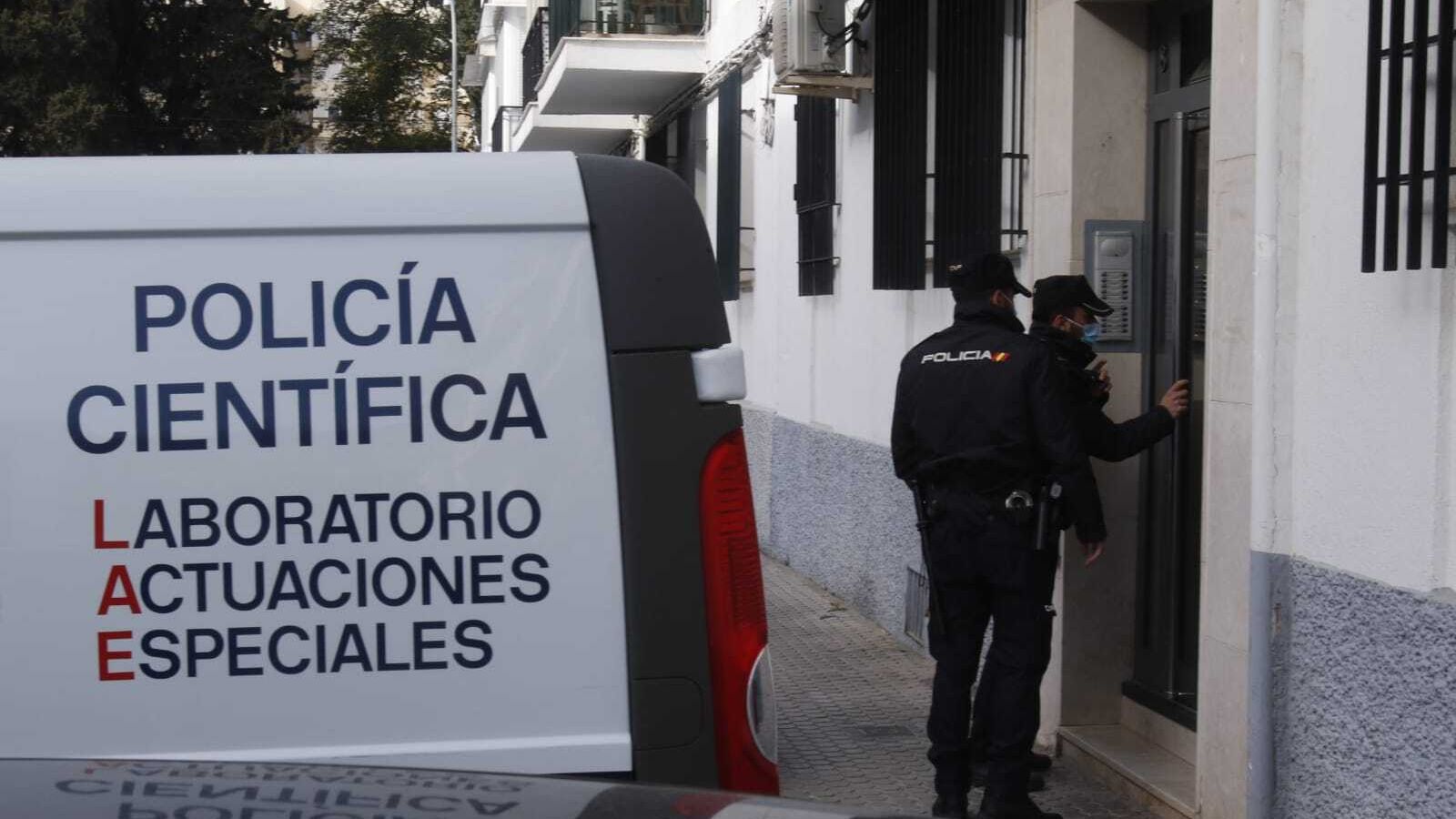 Agentes de la Policía Científica entran en el bloque de la vivienda incendiada.