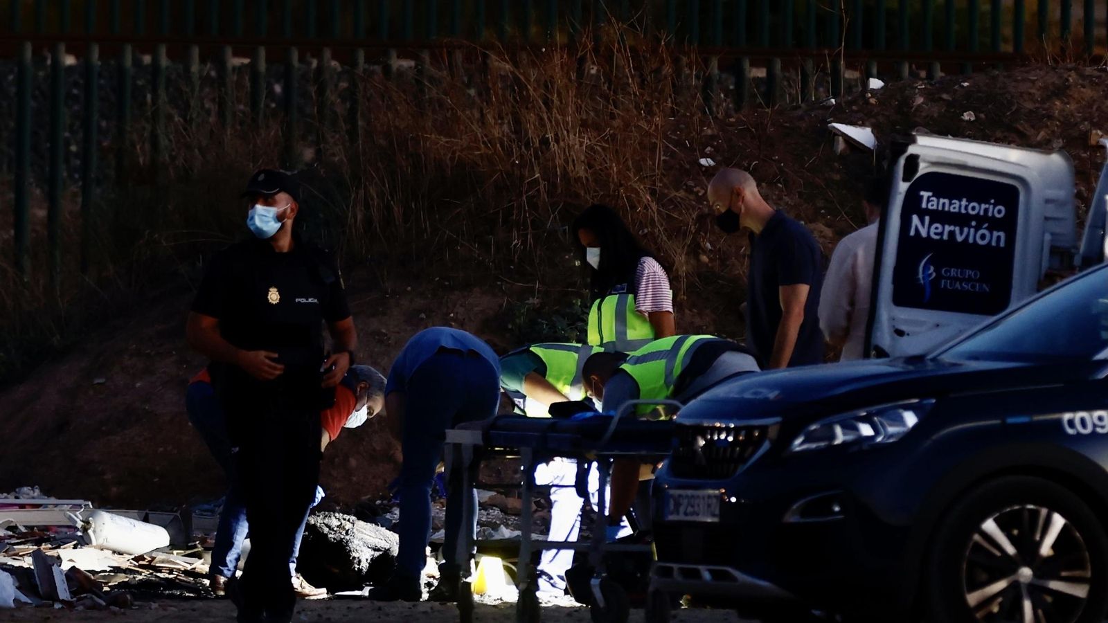 Policías y forenses examinan el cadáver.