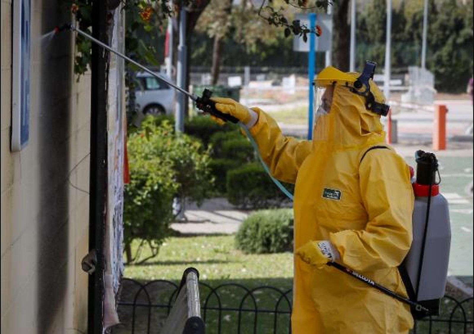 Un empleado municipal con traje protector desinfectando hoy las calles de Mairena del Aljarafe