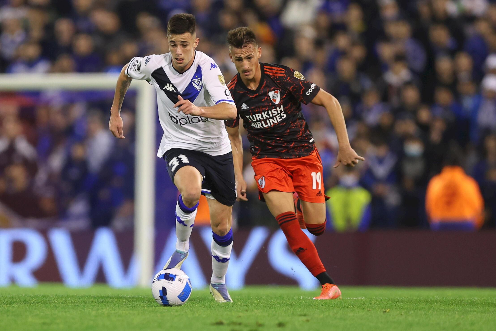 Valentín  Gómez disputa hoy el balón con Braian Romero, de River Plate.