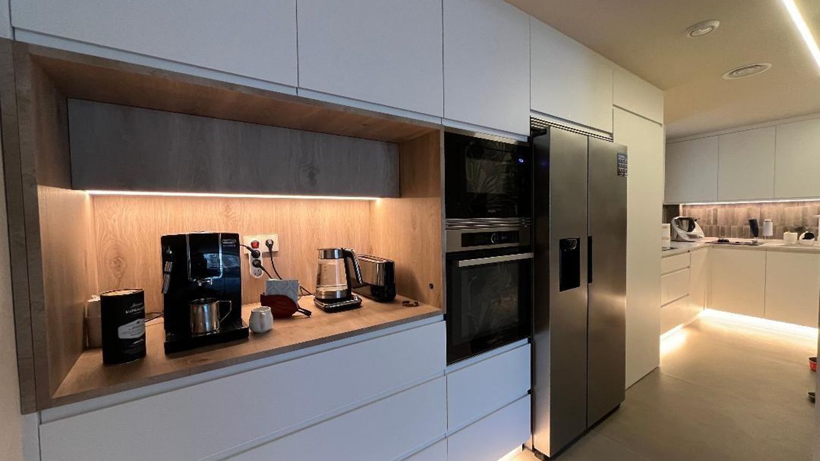 La cocina combina el lacado blanco de su mobiliario con el color madera de su encimera.