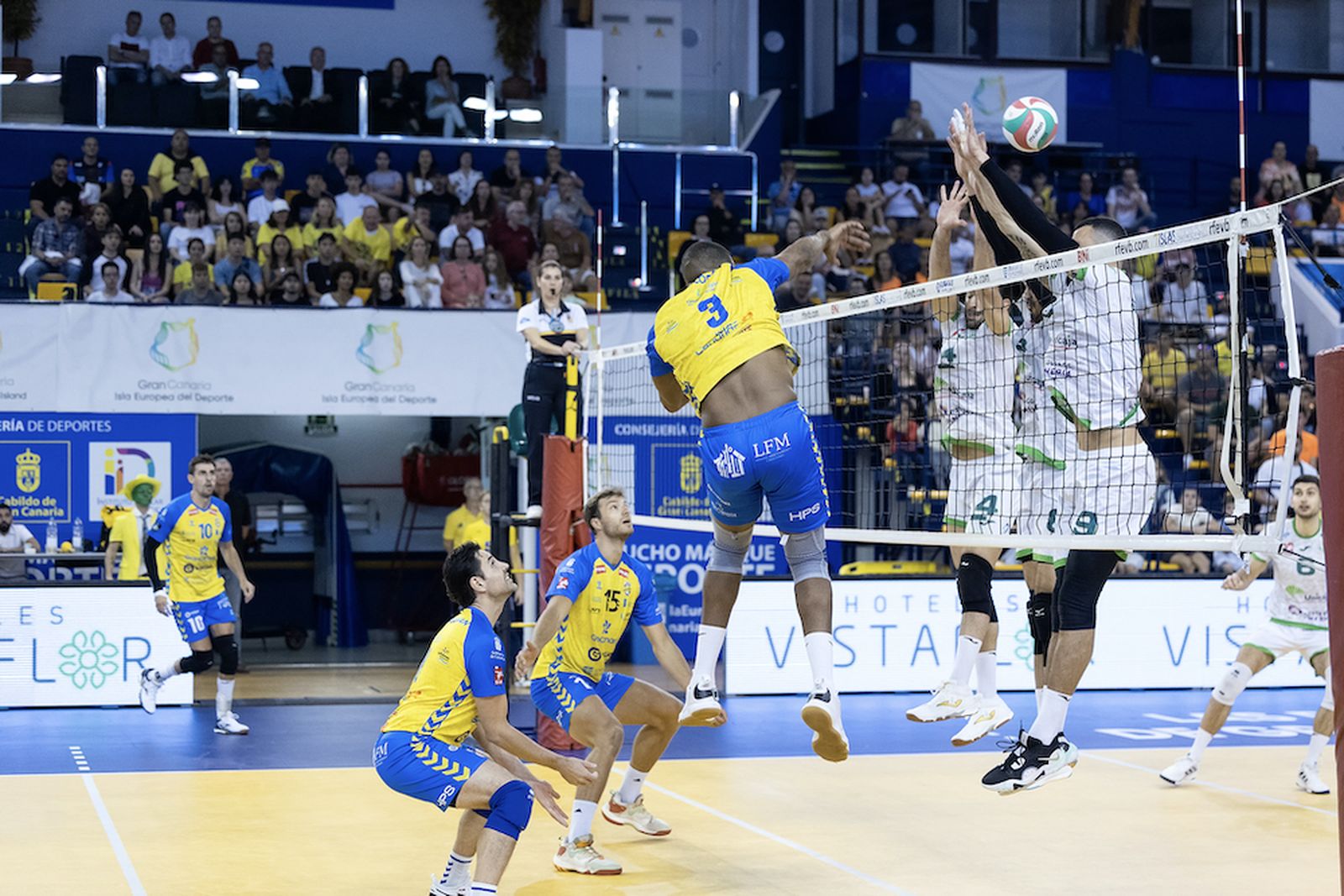 Dos jugadores ahorradores tratan de bloquear un remate del conjunto canario.