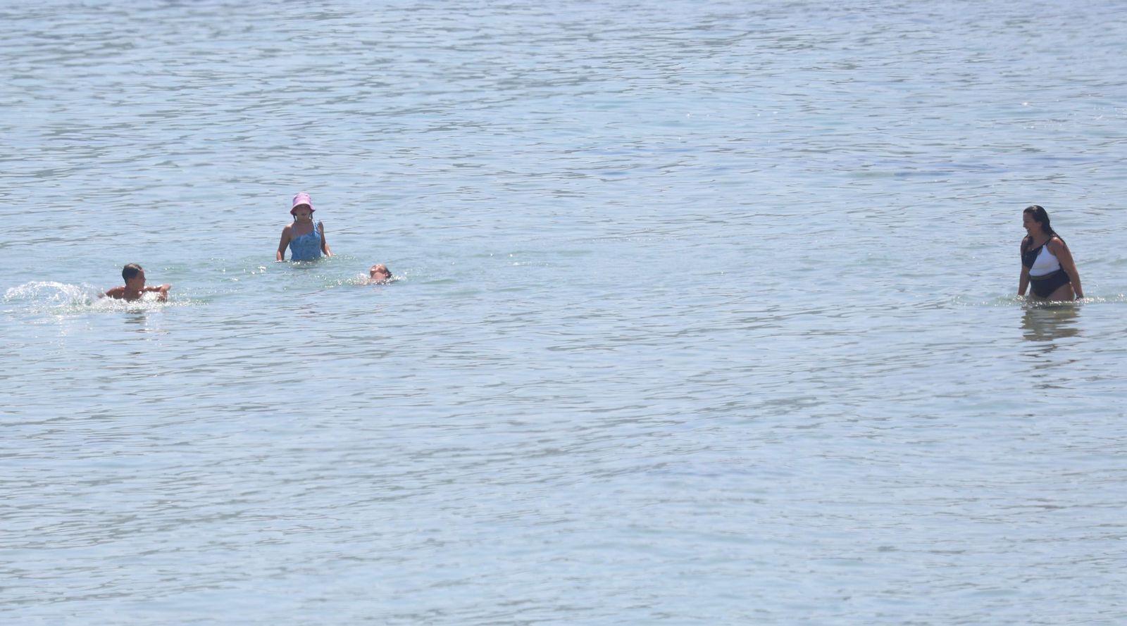 Varias personas se bañan en la playa de Getares.