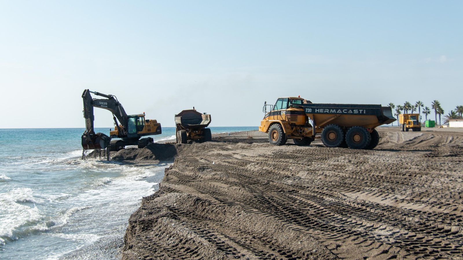 De forma paralela a la obra del espigón, una máquina recorta la playa de Poniente para regenerar la nueva ribera