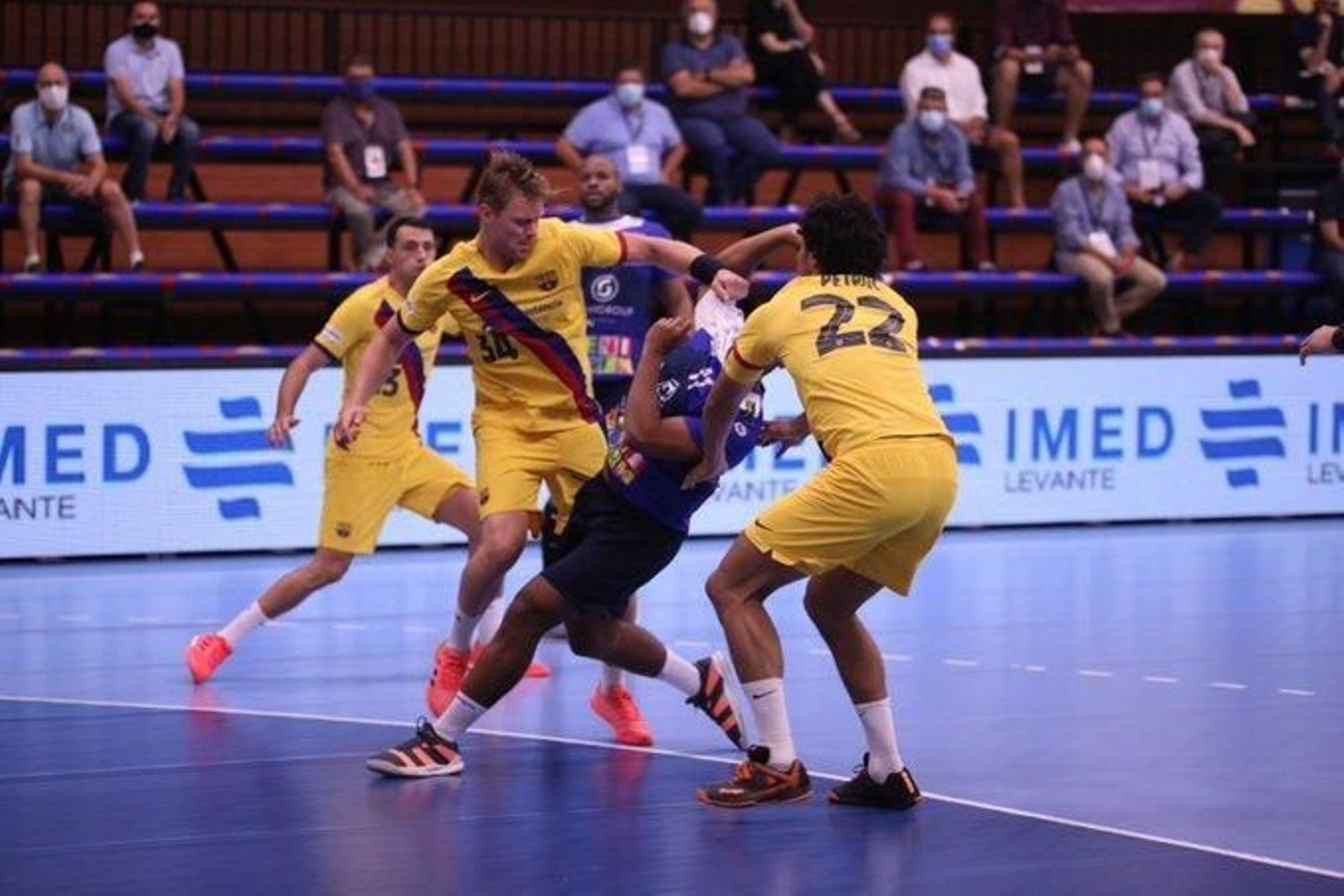 La defensa del Barça para a un jugador del Benidorm durante la Supercopa de España.