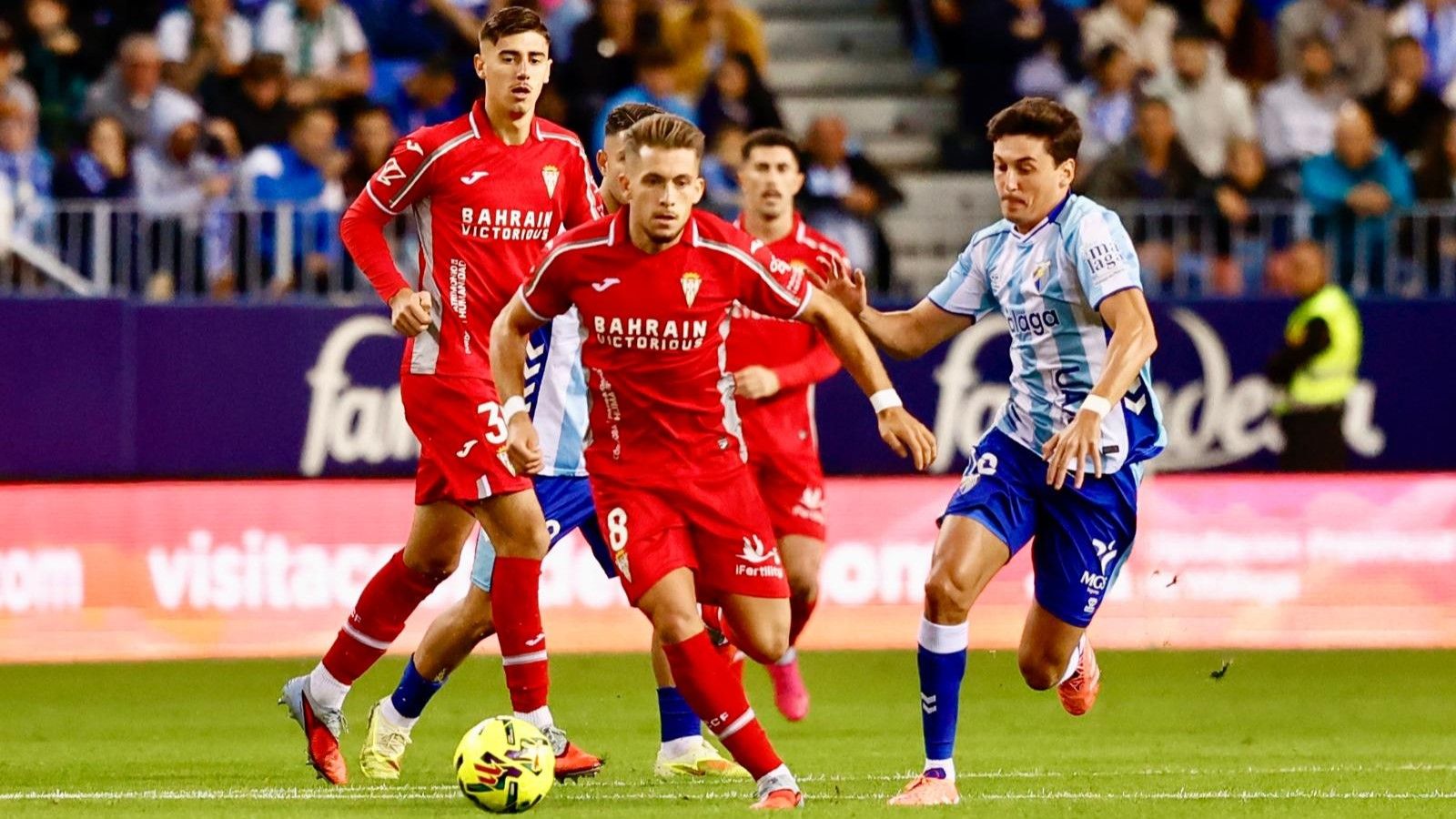 Isma Ruiz trata de superar a Dotor en el derbi andaluz entre el Málaga y el Córdoba CF.