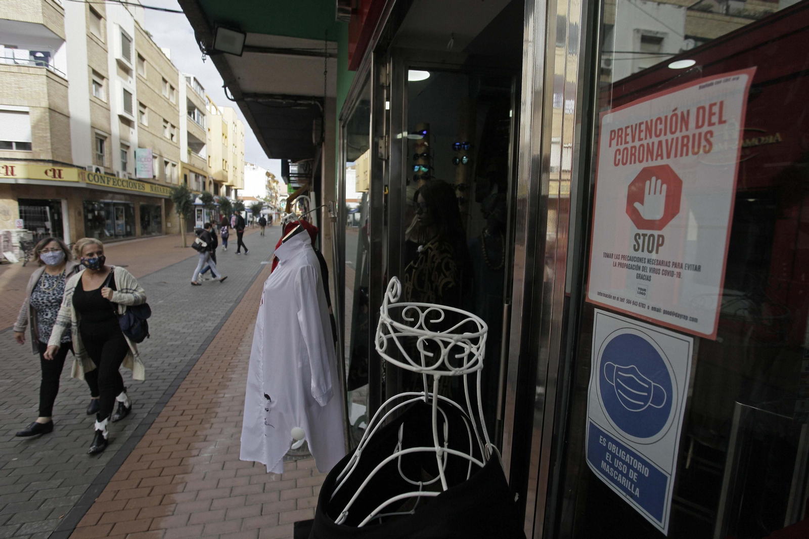 Dos mujeres miran un escaparate de una tienda en La Línea, este lunes.