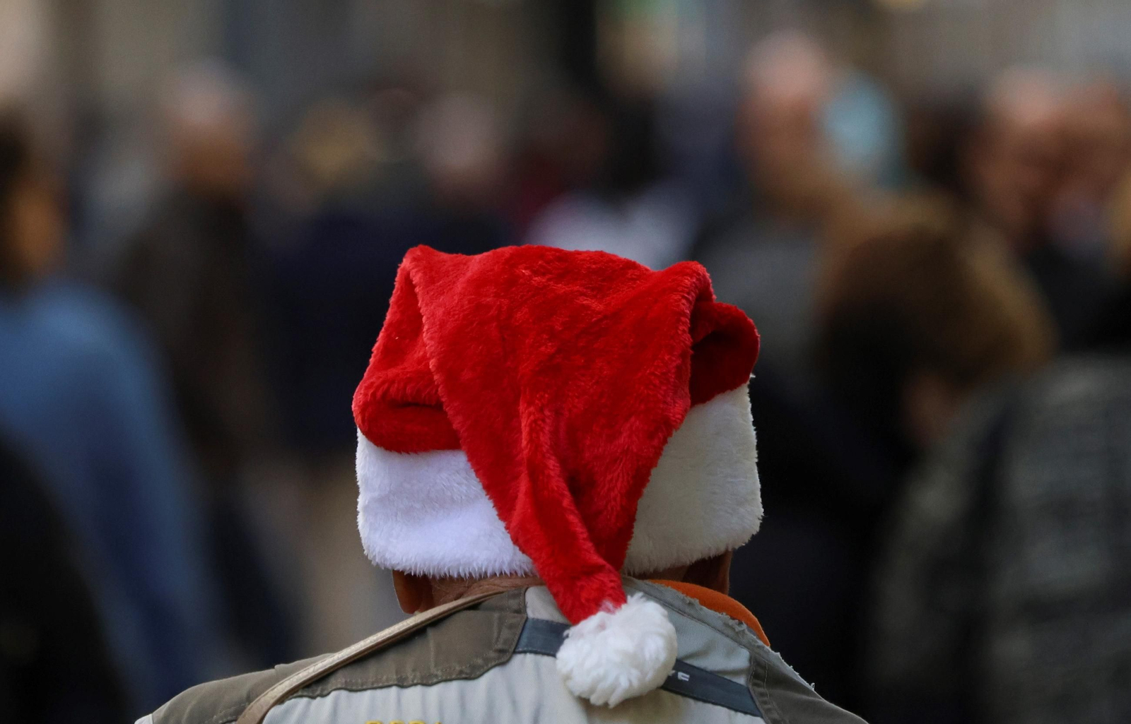 Un persona pasea por el centro de Málaga con un gorro de Papá Noel.