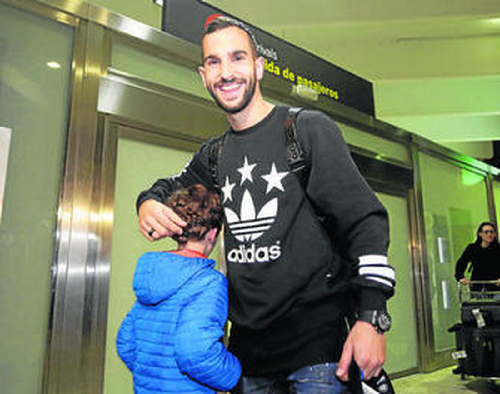 Martín Montoya, sonriente, saluda a un niño a su llegada anoche al aeropuerto de San Pablo.
