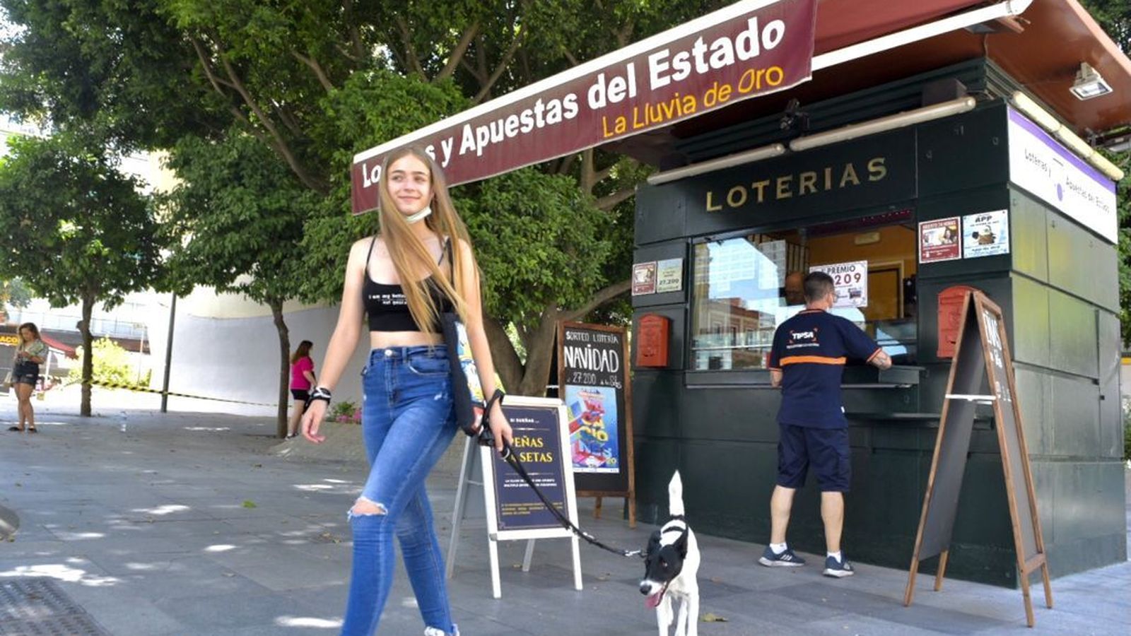 Una joven pasa con su perro junto a La Lluvia de Oro, en la Plaza de la Encarnación.