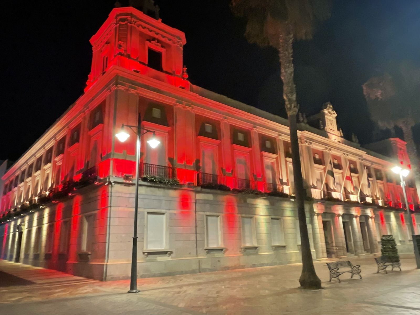 El Ayuntamiento de Huelva iluminado de rojo.