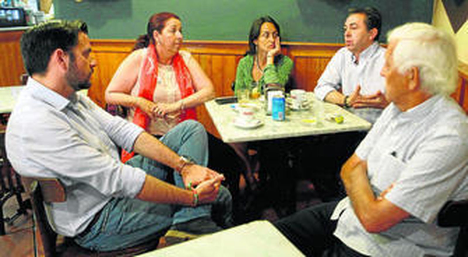 Fran González (izquierda) conversa con un grupo de parroquianos en el bar Casa Lazo.