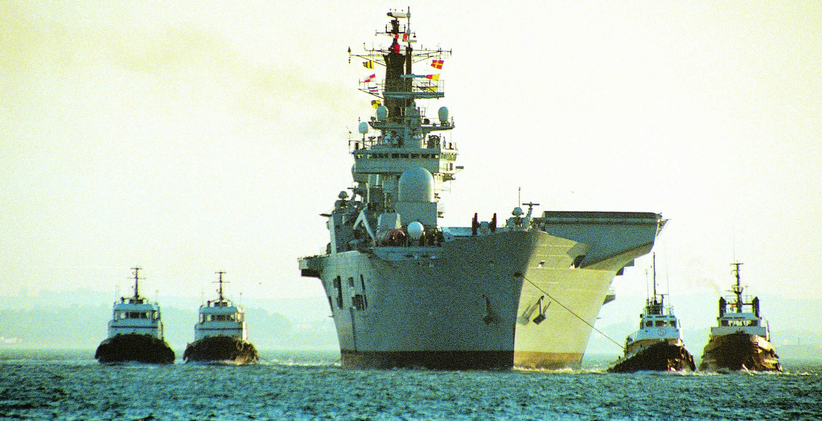 Varios remolcadores del puerto de Cádiz acompañando a un portaeronaves de la Armada.