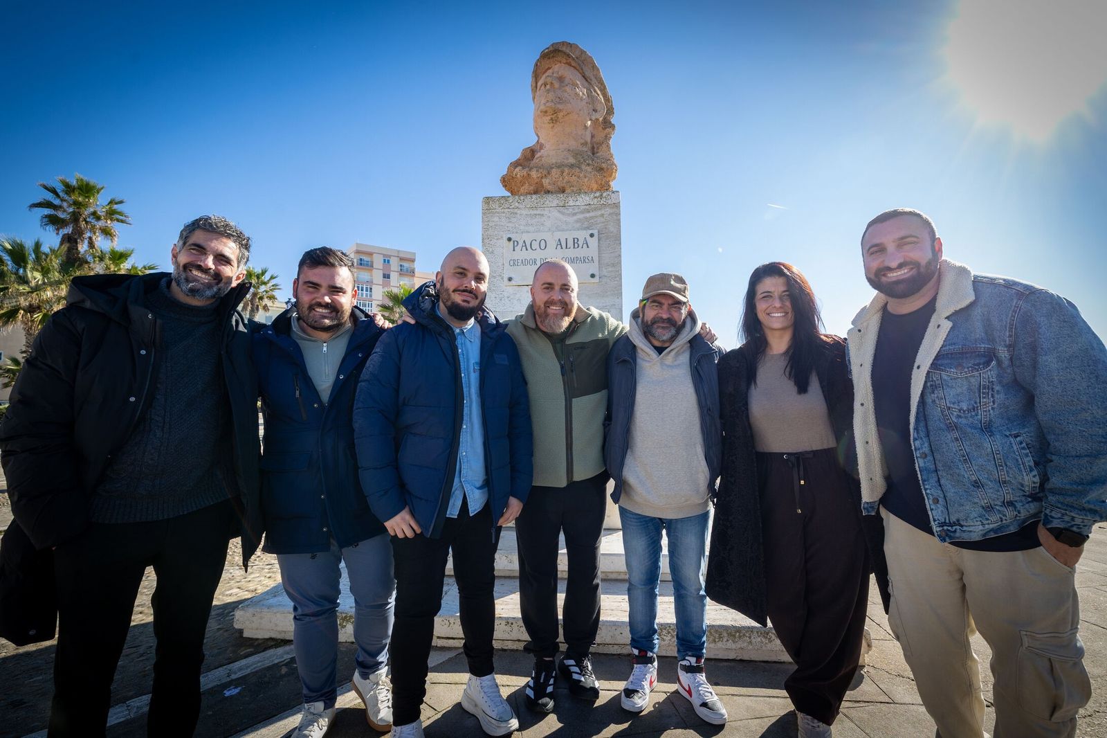 Comparsistas posan para Diario del Carnaval ante el busto de Paco Alba