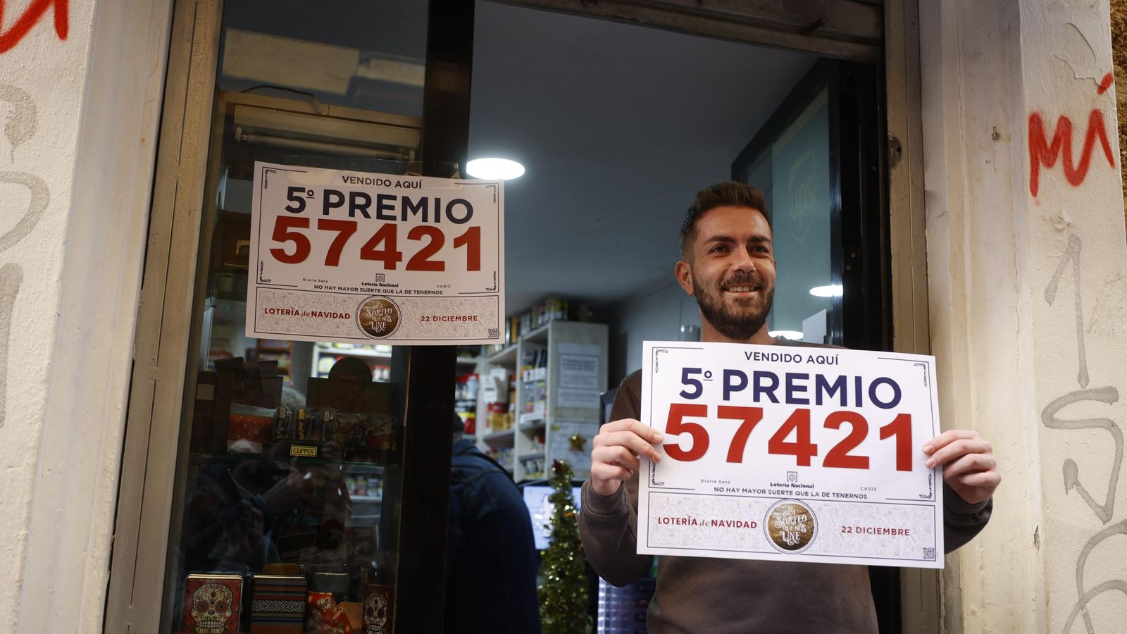Manuel Morillo, del estanco de la calle Rosario, muestra el cartel con uno de los quintos premios.