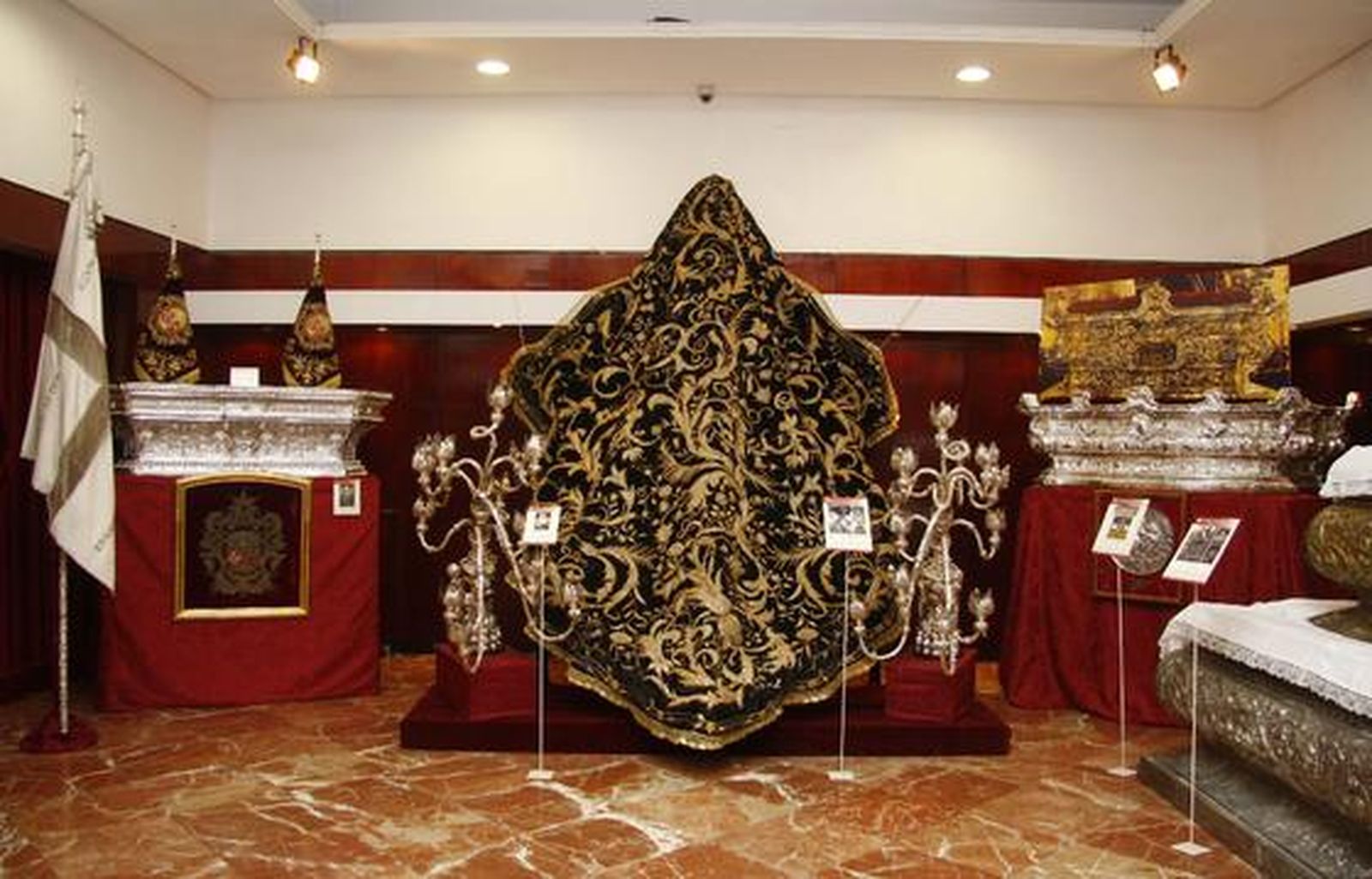 Los visitantes aprecian los objetos de la exposición "Tan lejos y tan cerca", de la Hermandad de la Amargura.

Foto: Belen Vargas