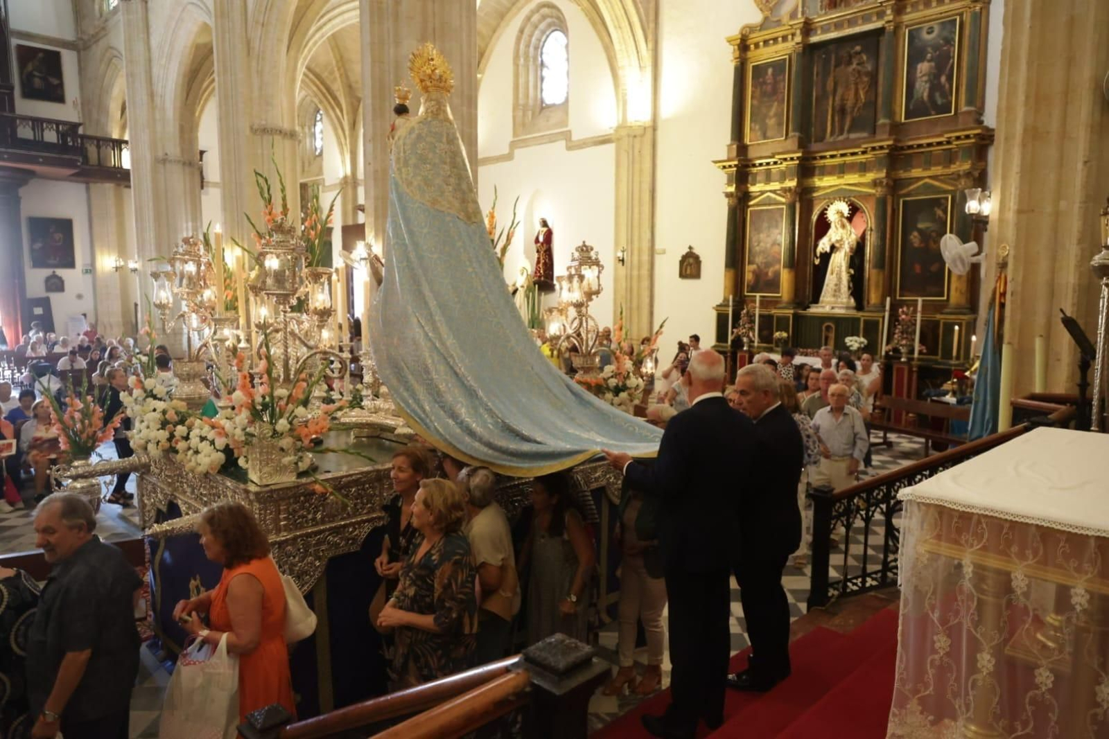 Los fieles pasan bajo el manto de la Virgen de la Luz.