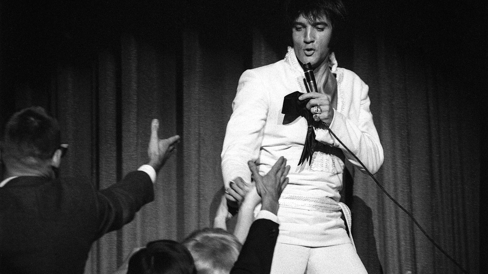 Elvis, en plena actuación, con su mítico mono blanco.