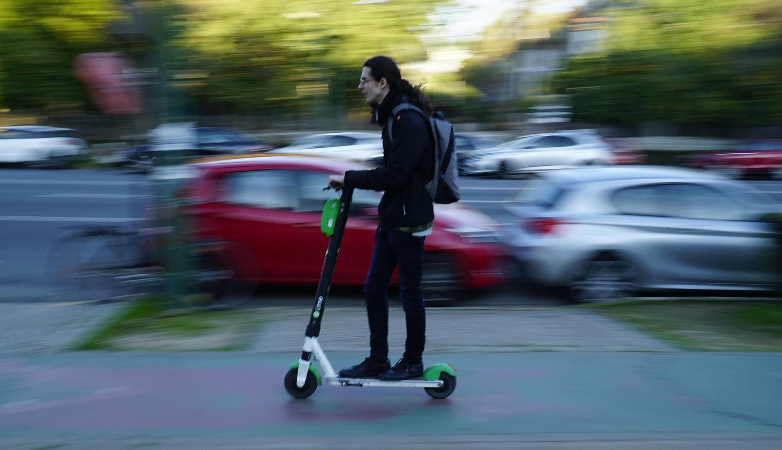 Un joven circular en patinete eléctrico, correctamente, por el carril bici. Un joven circular en patinete eléctrico, correctamente, por el carril bici.