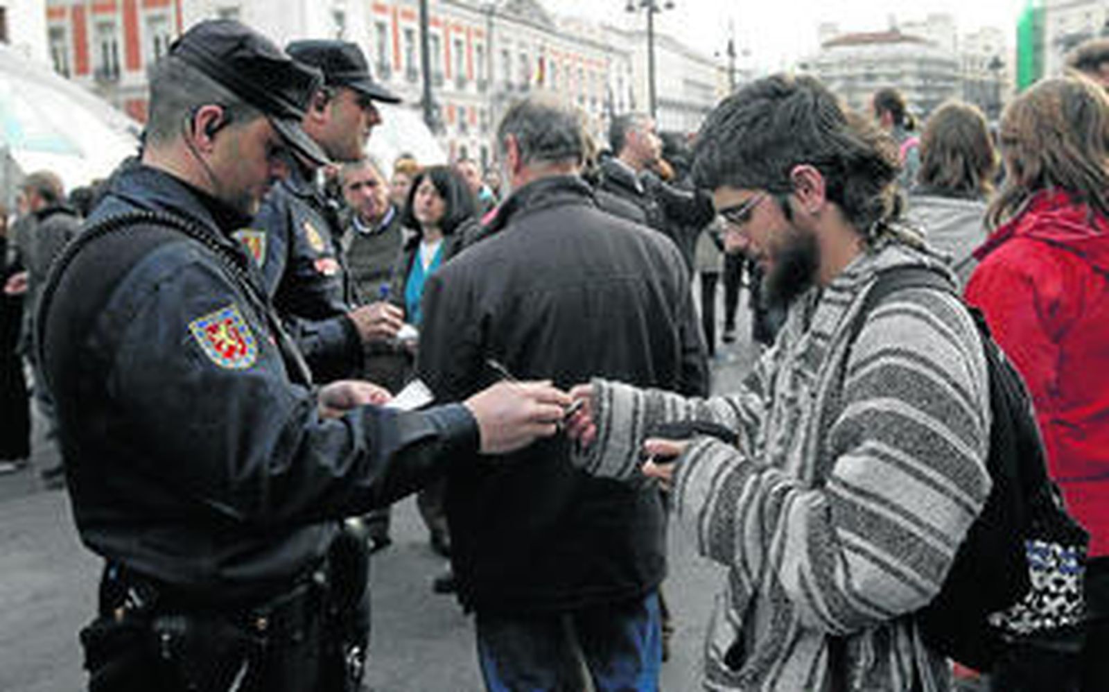 Varios policías piden la identificación a un joven hace un año en la Puerta del Sol de Madrid.