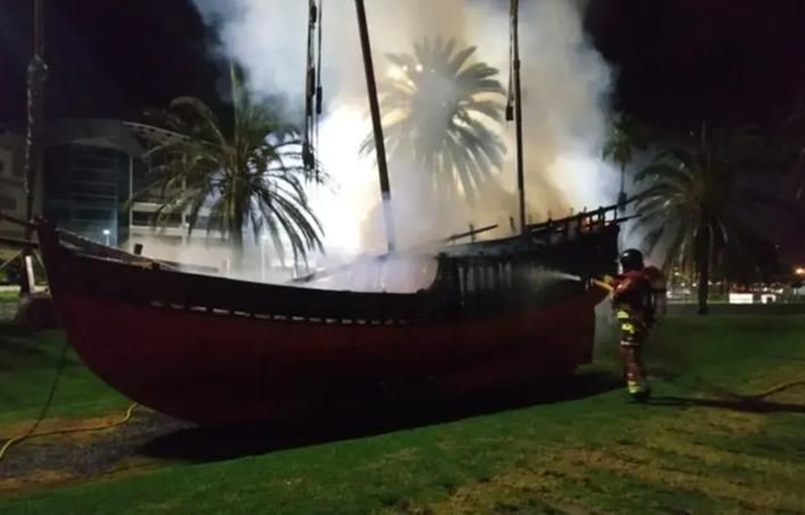 Los bomberos tratan de apagar el incendio en la réplica de 'la Niña'.