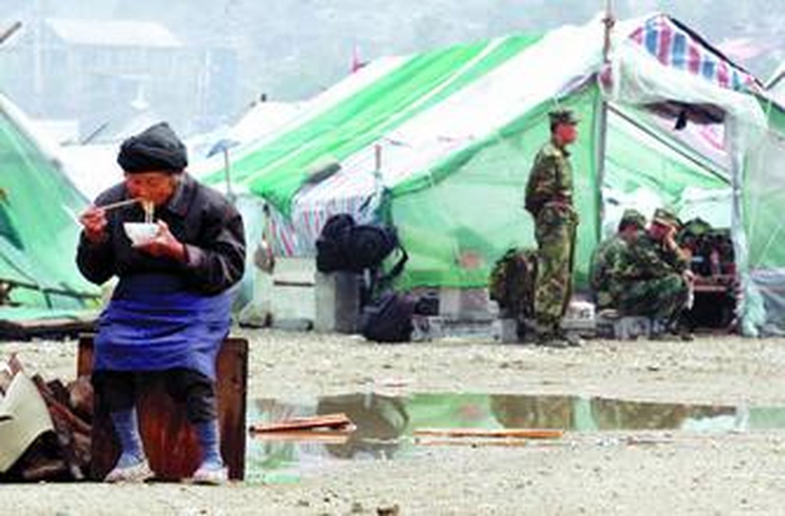 Una mujer que ha sobrevivido al desastre come en uno de los campamentos habilitados.