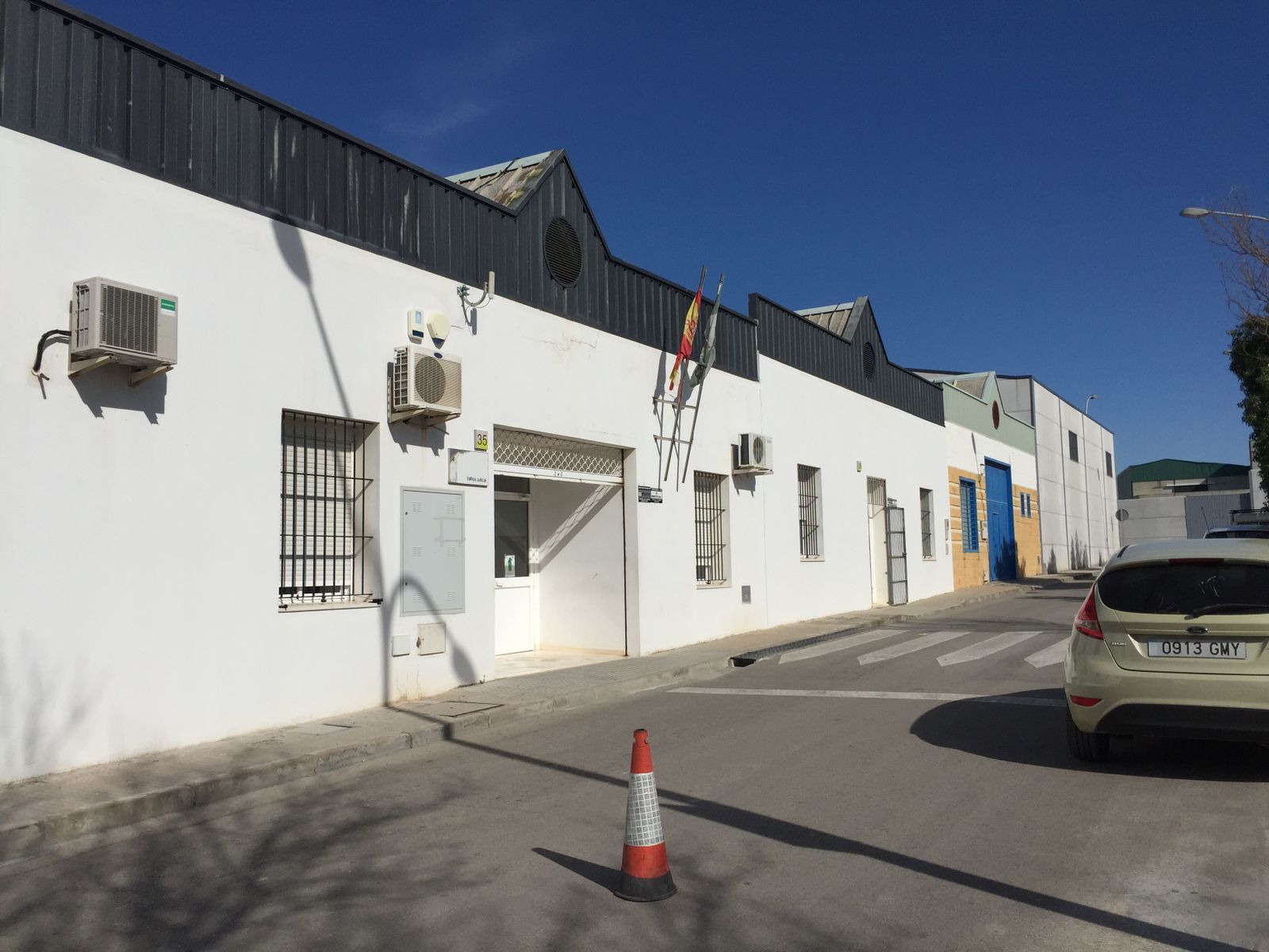 Solo las banderas distinguen los juzgados de Osuna del resto de negocios del polígono industrial