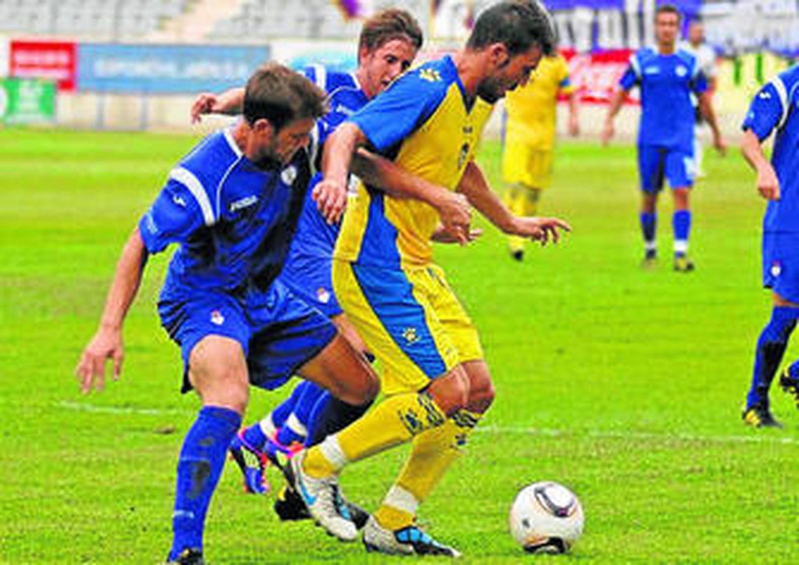 Dioni pugna con dos rivales del Jaén en el choque de la primera vuelta.