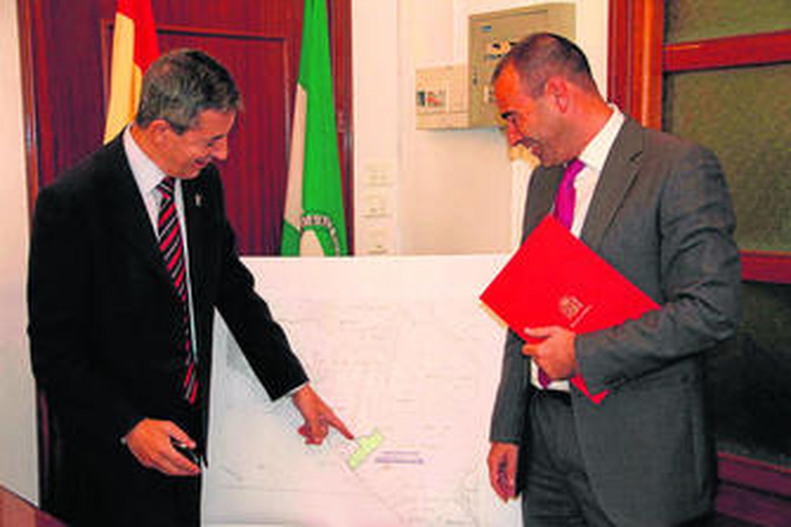 El secretario de Estado señala sobre plano y ante el alcalde el lugar de ubicación de la futura piscifactoría.