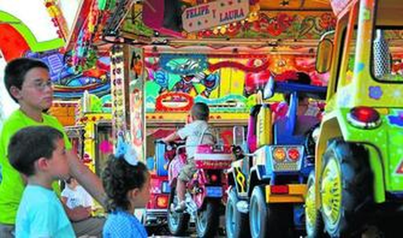 Unos niños observan uno de los circuitos de coches, motos y camiones que hay en la Feria.