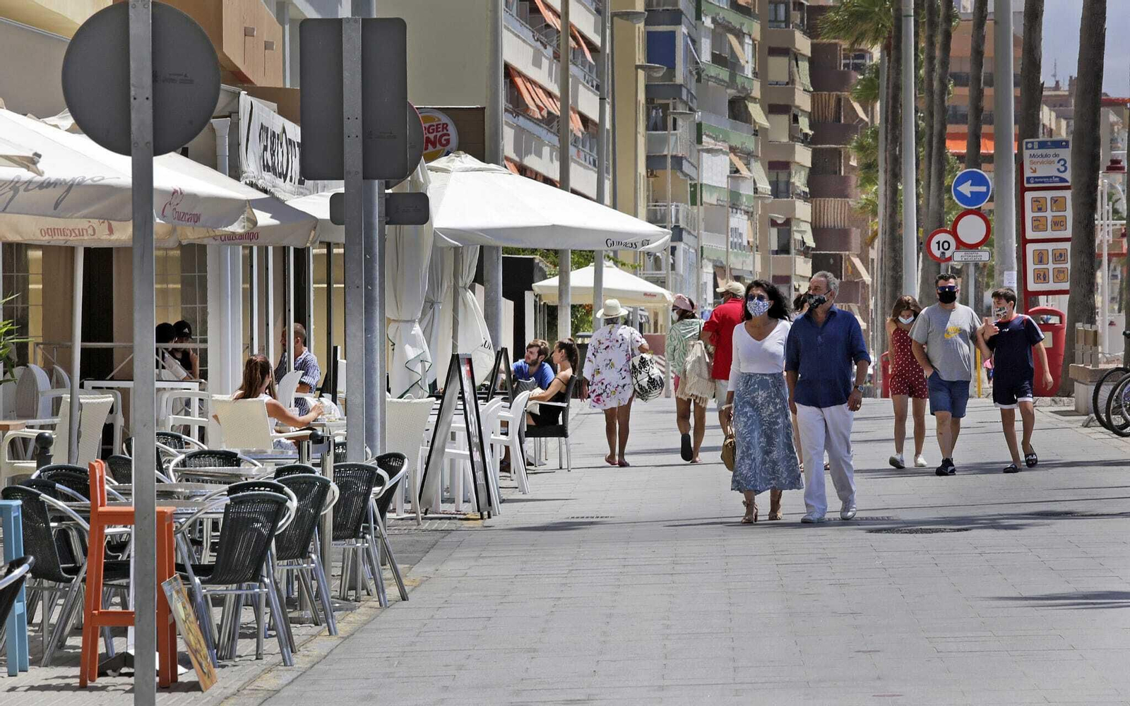 Personas paseando por el paseo marítimo en Cádiz.