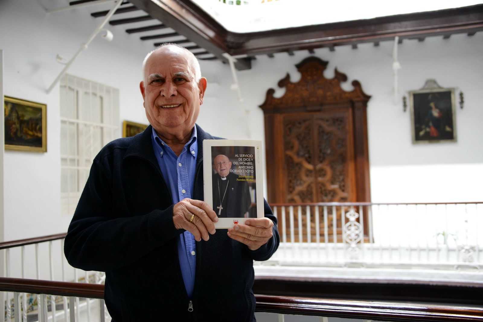 El sacerdote Juan Antonio Paredes Muñoz con su libro en el convento de las monjas franciscanas del Rebaño de María.
