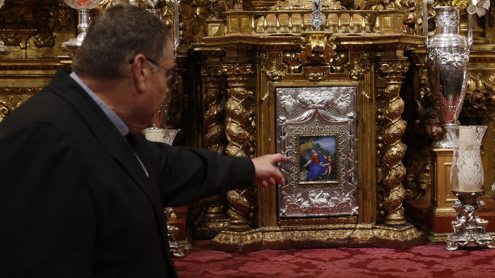 El párroco enseña una de las pinturas del Sagrario.