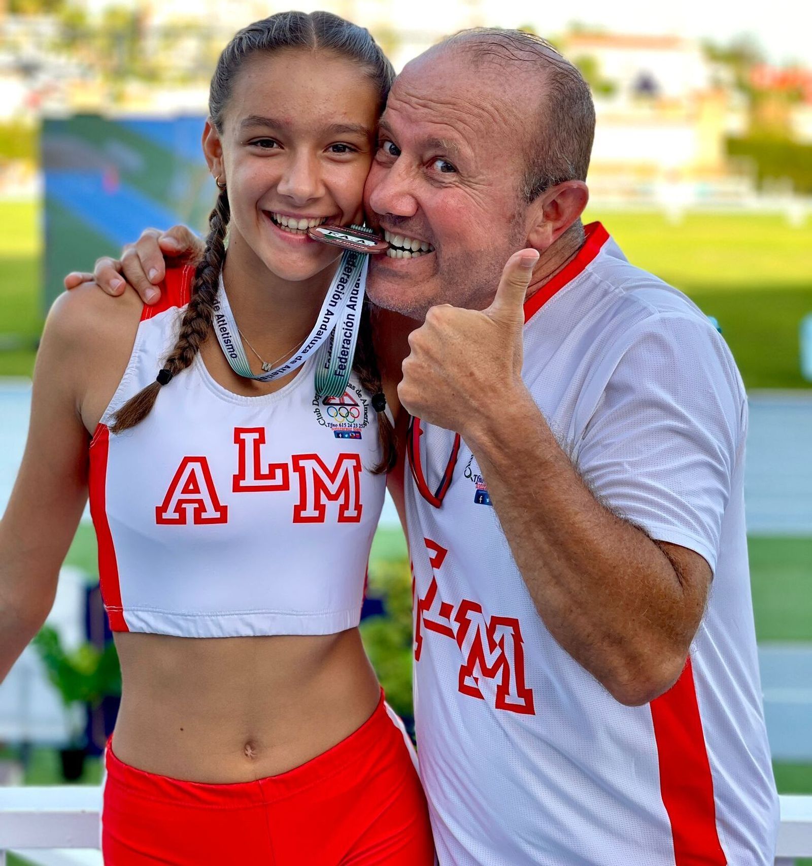 La atleta Mónica Gómez posa junto a su entrenador con la medalla de bronce en el Campeonato de Andalucía Absoluto.