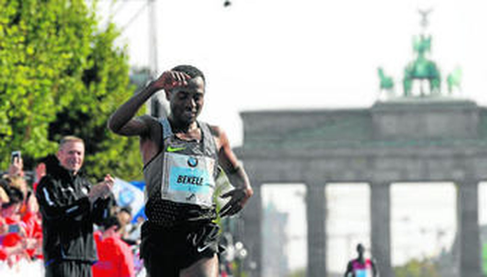El etíope Kenenisa Bekele entra en la línea de meta en Berlín con la Puerta de Brandenburgo al fondo.