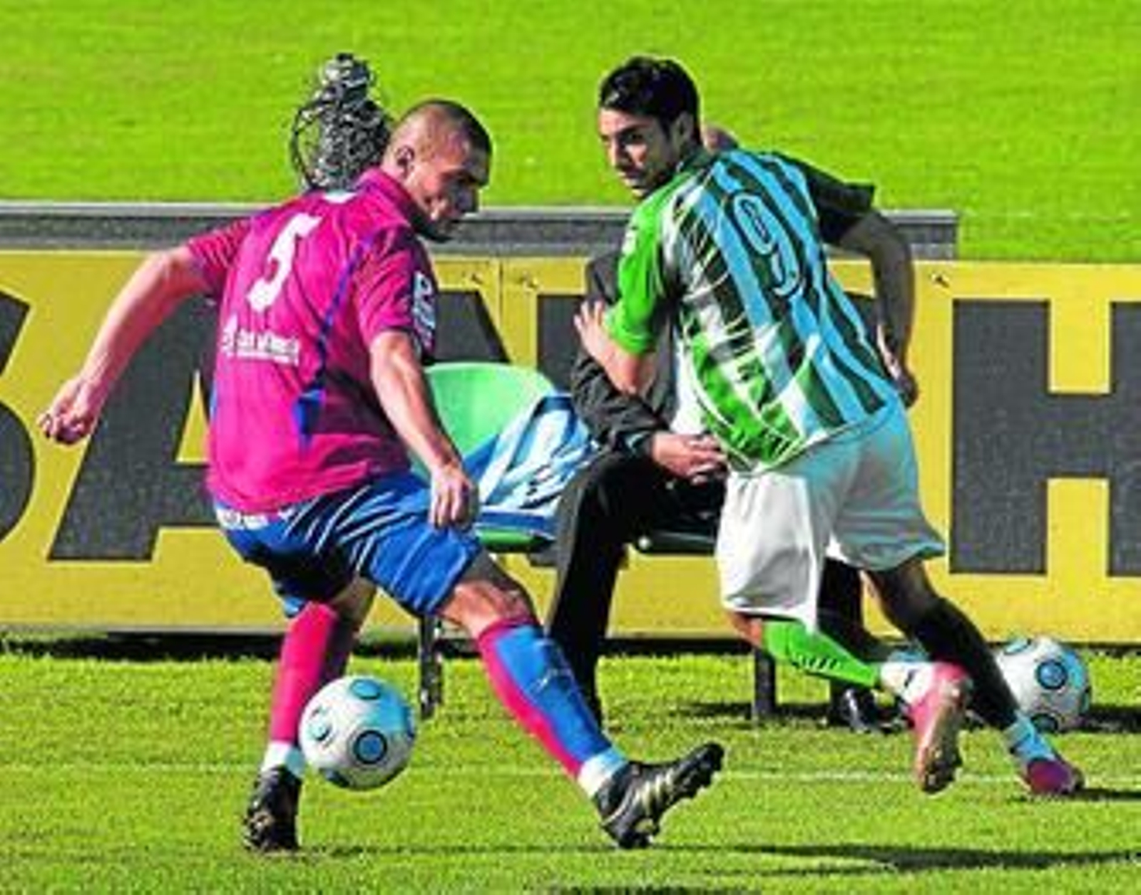 Juan Moreno consigue dar un pase ante el central del Roquetas Castillo.