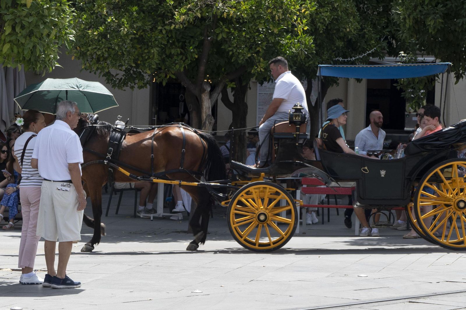 Una pareja se protege del sol en Sevilla