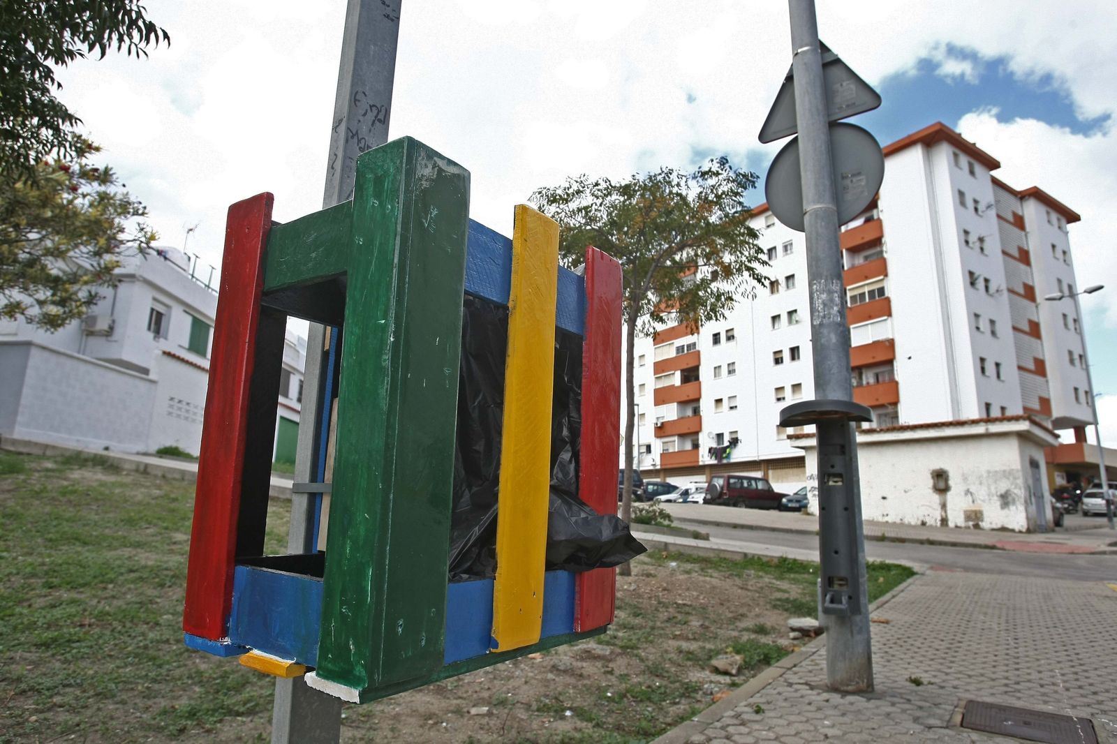 La papelera multicolor, pegada a una farola de la calle Antonio Marchado.