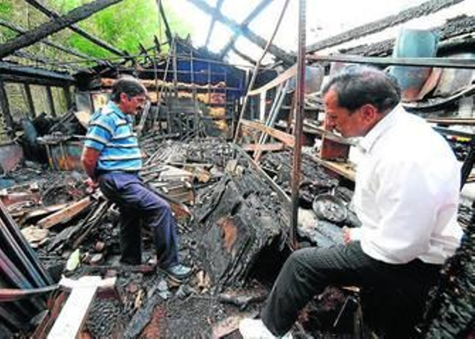 1. El propietario de un negocio de Londres recogía ayer los restos calcinados de su tienda junto a uno de sus empleados. 2. Un trabajador limpia los cristales rotos en la puerta de una lavandería después de una noche llena de altercados violentos en el vecindario de Toxteth, en Liverpool. 3. Un forense revisa el área de Winson Green en la ciudad de Birmingham, donde tres hombree murieron en los disturbios. 4. Dos operarios valoran los daños sufridos en una vivienda londinense calcinada el martes por la noche en Claphan, Londres.