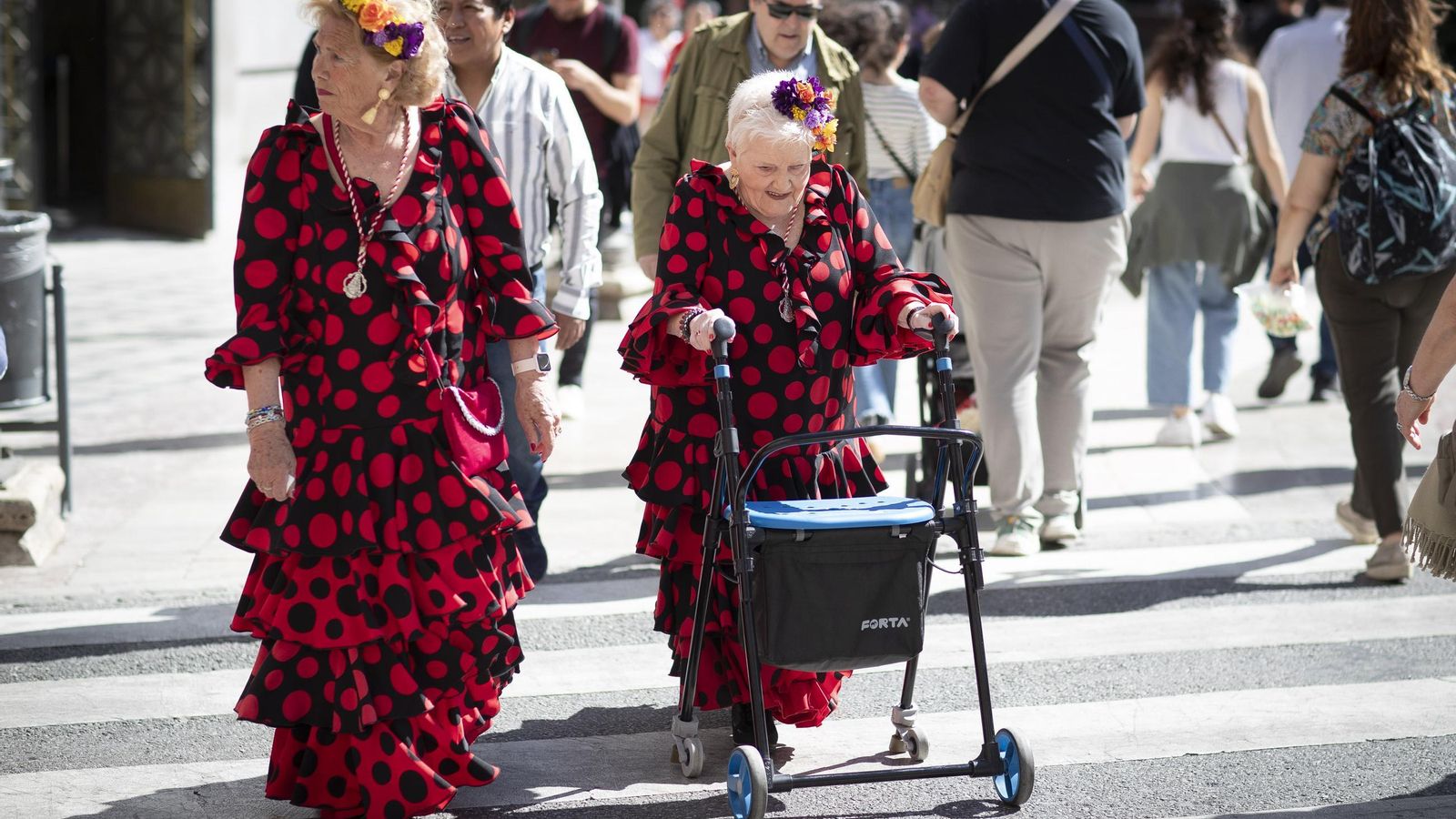 Dos mujeres caminan por el Centro de Granada vestidas de flamenca