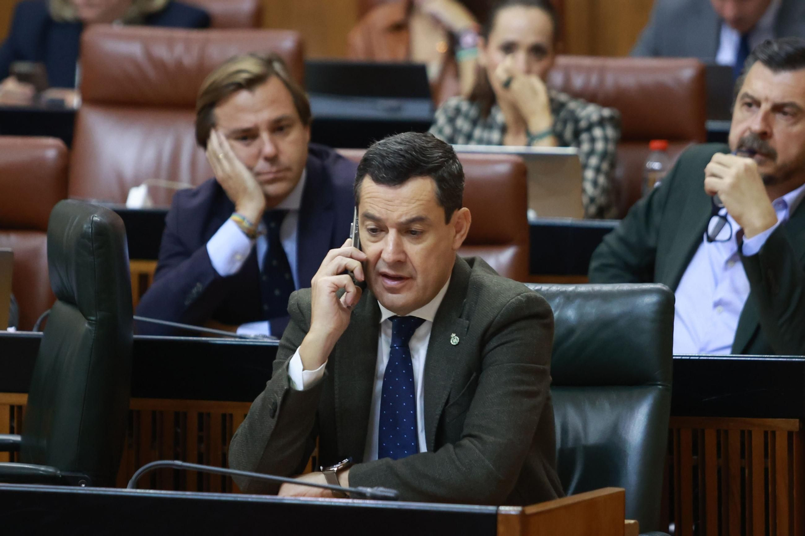 Juanma Moreno habla por teléfono durante el debate de totalidad de los Presupuestos Juanma Moreno habla por teléfono durante el debate de totalidad de los Presupuestos