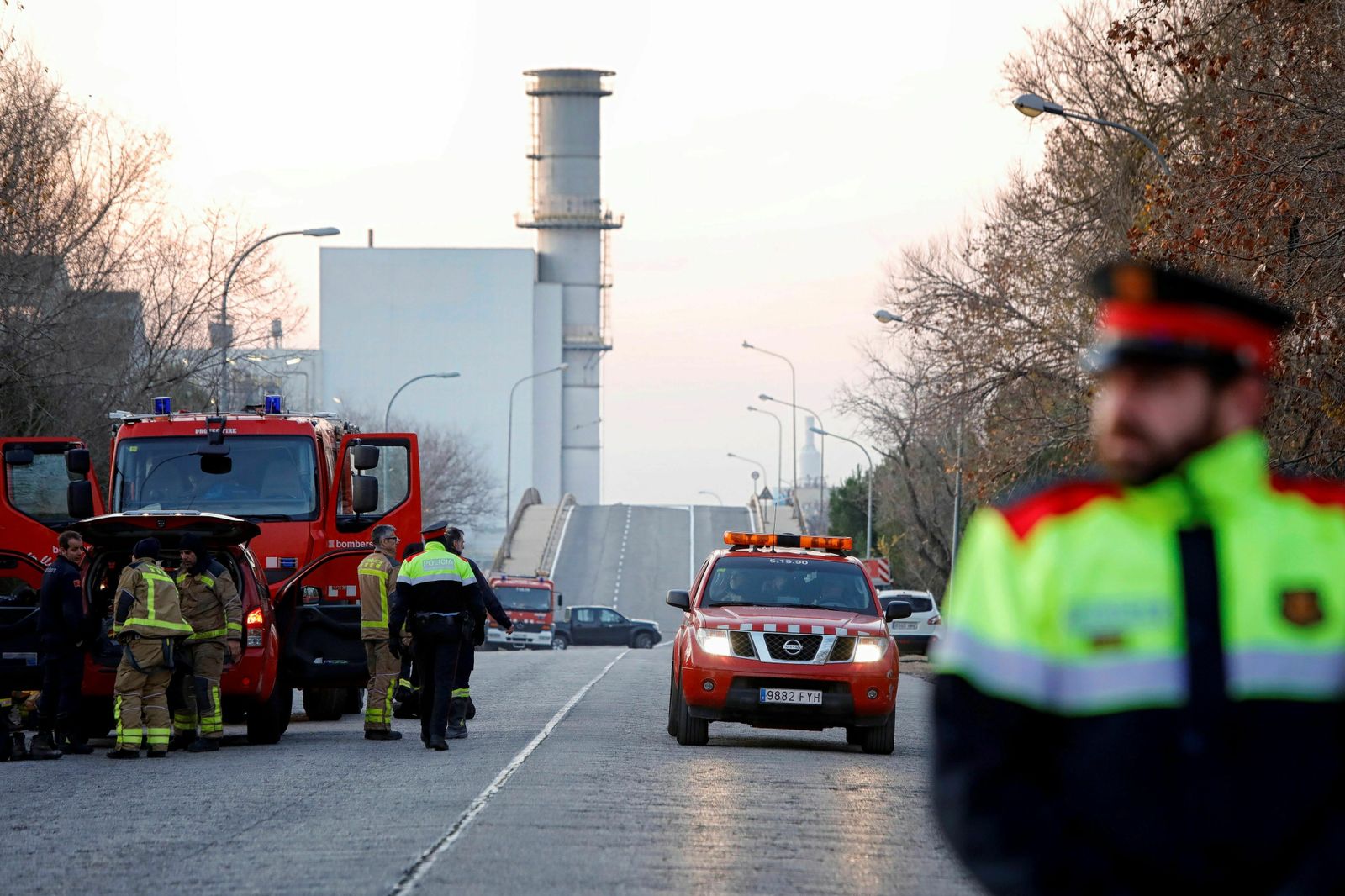Un mosso y los bomberos en las inmediaciones de la petroquímica