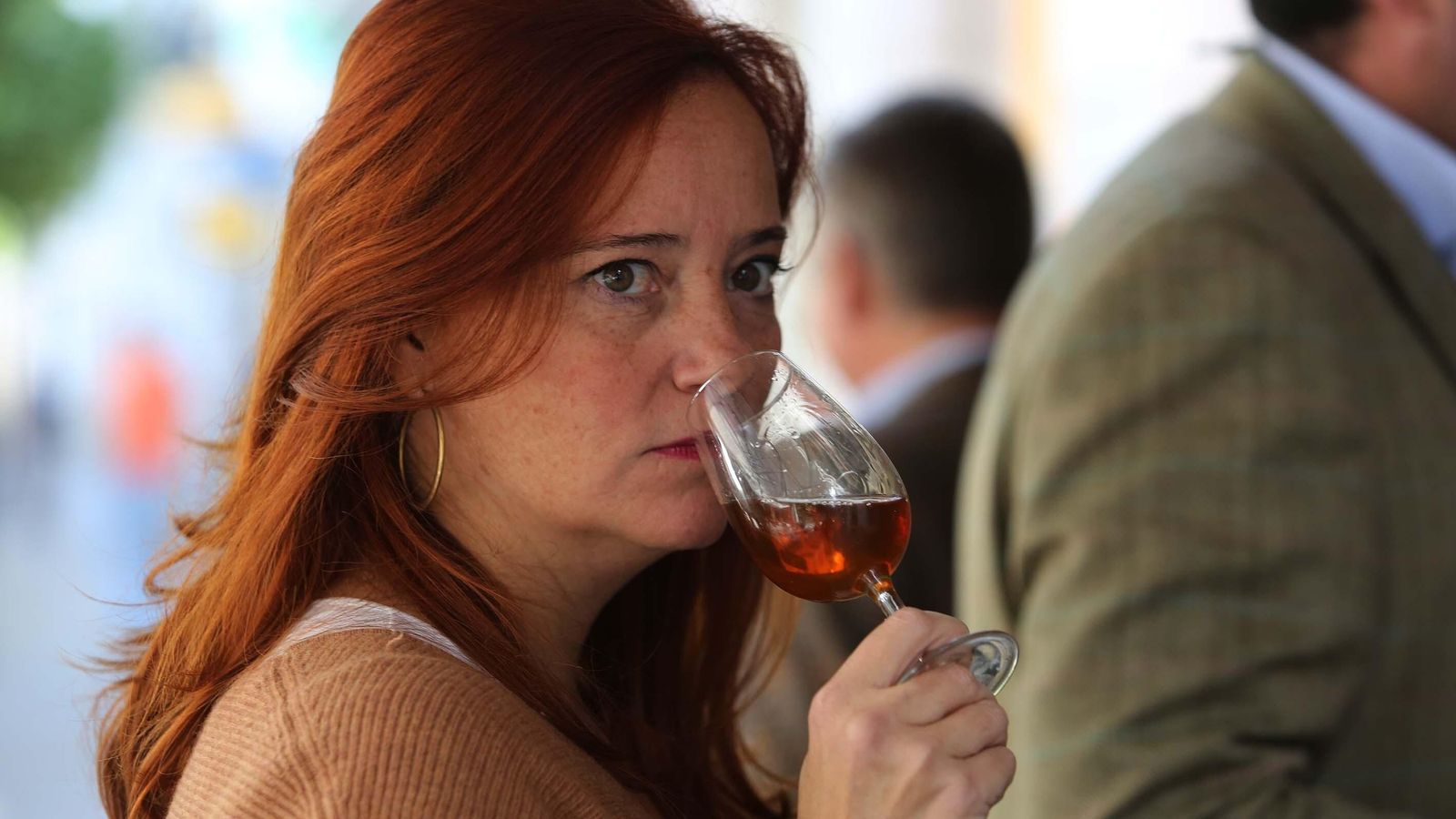 Una mujer consumiendo una copa de vino de Jerez. Una mujer consumiendo una copa de vino de Jerez.
