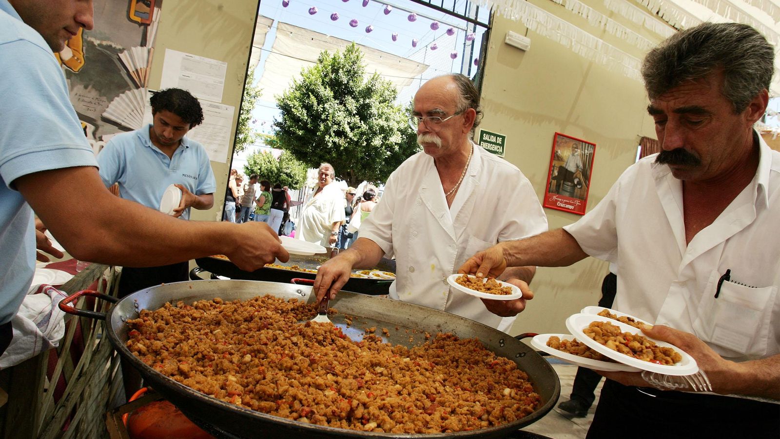 Reparto de un plato de migas en la Feria de Málaga.