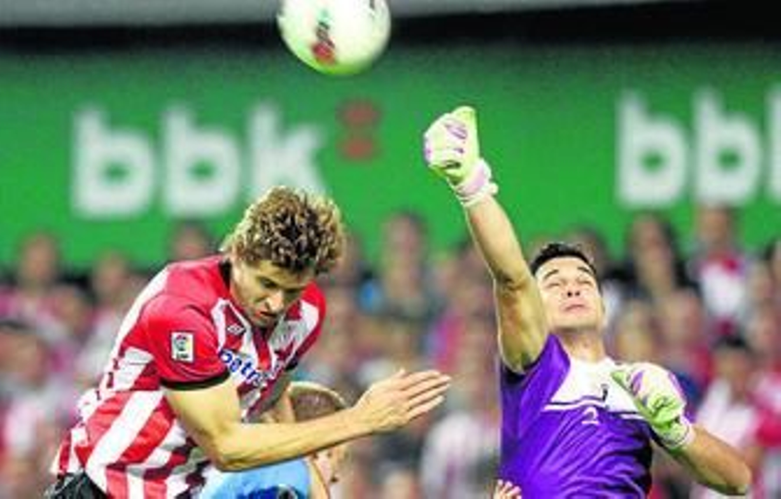 El guardameta osasunista Andrés despeja de puños ante el intento de remate de Llorente.