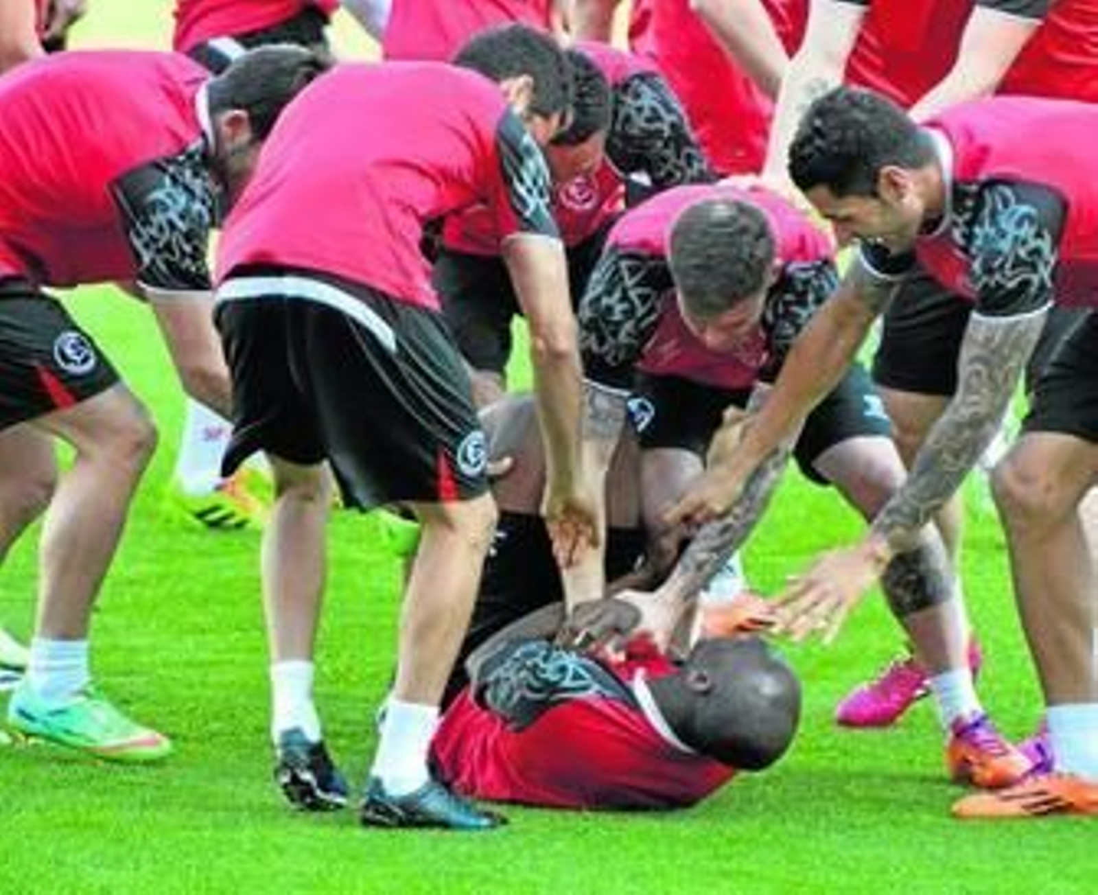 M'Bia, en el suelo, recibe las bromas del resto de la plantilla.