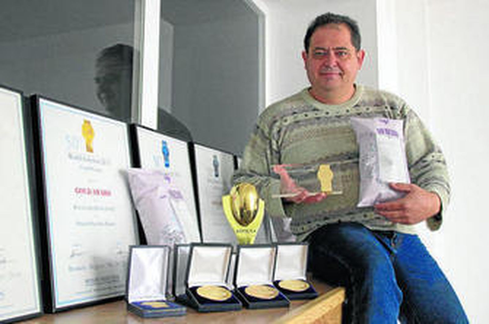 Rafael posa con los premios cosechados por su empresa. Abajo, proceso de elaboración de las patatas fritas.
