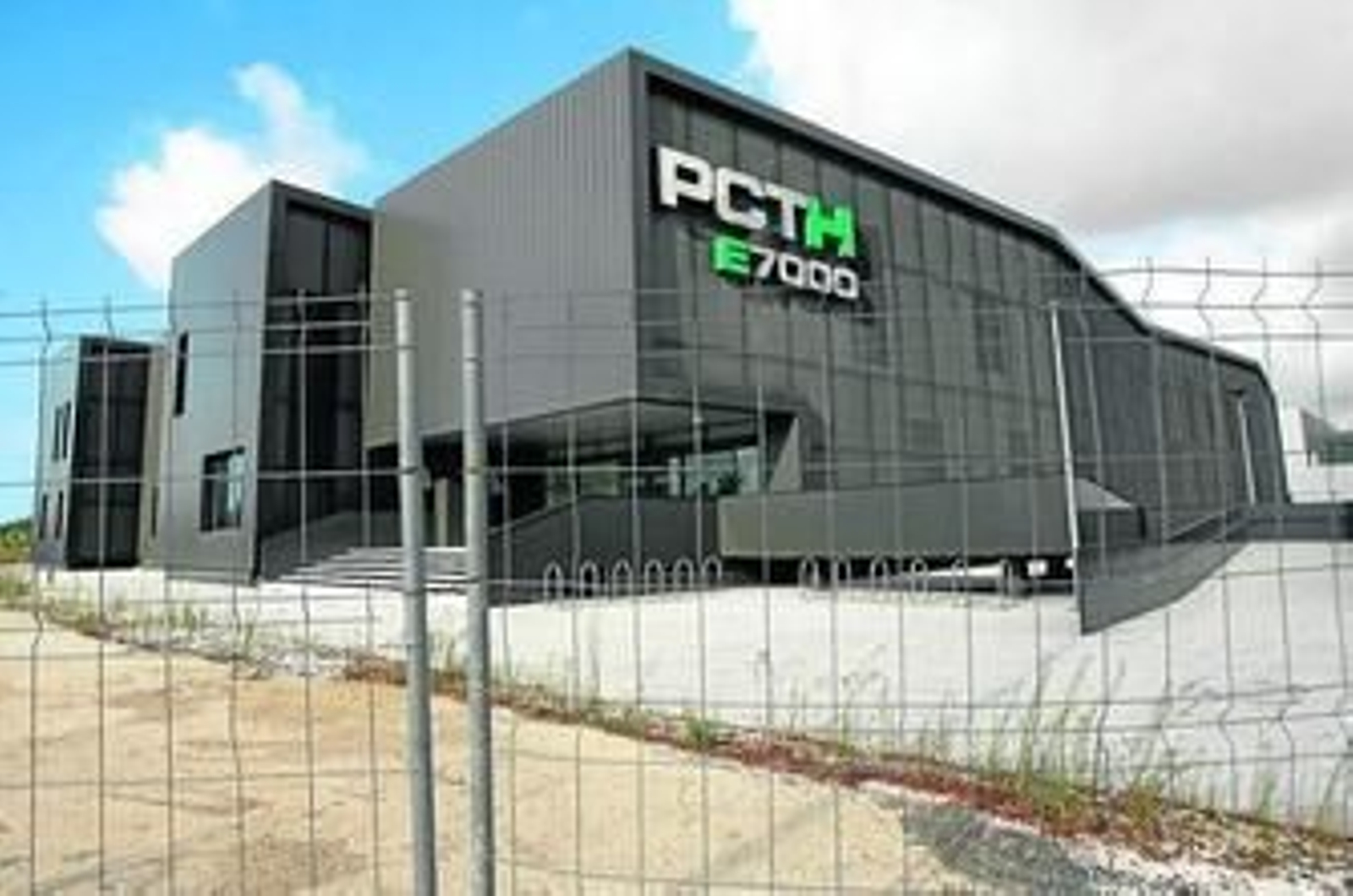 Fachada del edificio E7000, del PCTH de Aljaraque, rodeado de vallas de obras por no haber sido aún entregado.