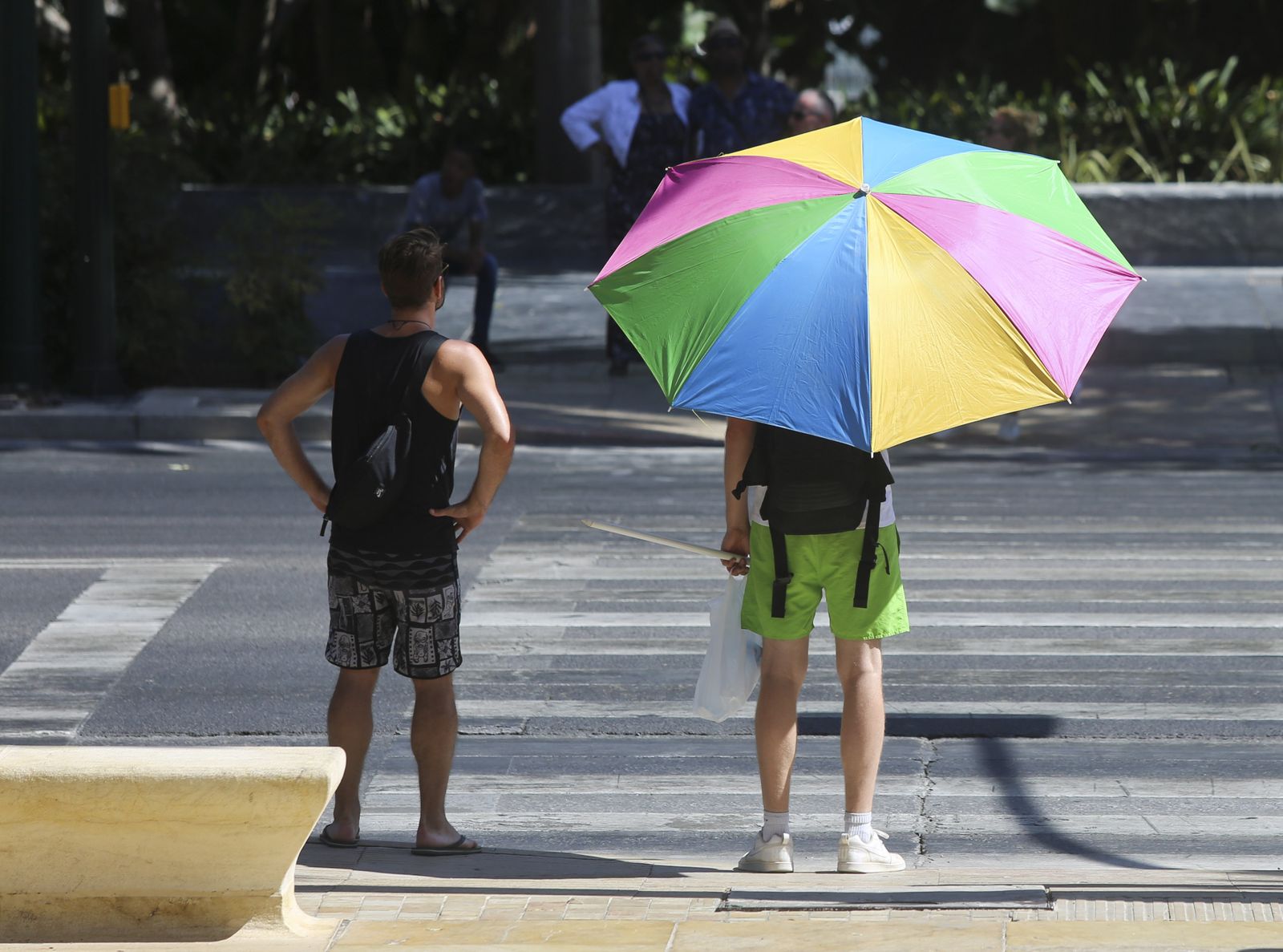 Dos turistas se protegen del sol este martes en la Málaga capital.
